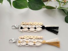 two crocheted keychains with words that spell out loved on them and tassels