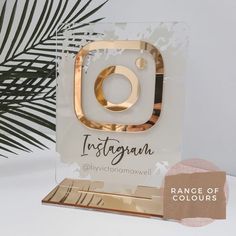 an instagram logo is displayed on a clear acrylic plaque with gold accents