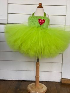 a green tutu skirt with a red heart on it sitting on top of a mannequin