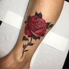 a red rose tattoo on the leg