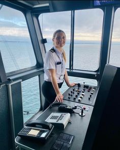 a woman standing on the deck of a boat with controls and sound equipment in front of her