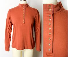 "A great vintage 1990s tee featuring mock neck, henley style buttons, long sleeves, cute button detail at each cuff, and a beautiful warm rust / clay hue. A great vintage basic - ideal for layering! Label : Natural Reflections Fabric Content: 60% Cotton, 40% Polyester Approximate Size: Medium. Would also fit a small.  To ensure a good fit, please compare measurements with a similar piece from your closet. Measurements are of the actual garment, not of your body.  Marked Size: Medium Measurements Chic Jeans, Stylish Jeans, Mock Neck Long Sleeve, Fun Pants, Velvet Blouses, Henley Shirt, Henley Top, Dress Form, Henley Shirts