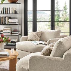 a living room with two couches and a coffee table in front of large windows