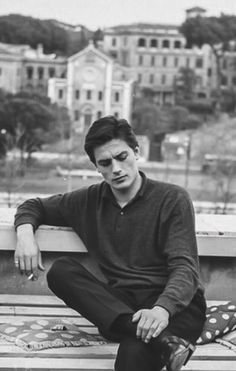 a man sitting on top of a wooden bench