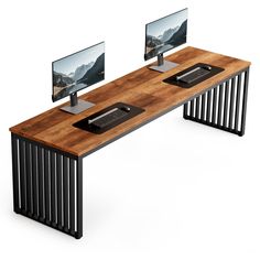 two computer monitors sitting on top of a wooden desk next to each other with black metal legs