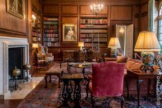 a living room filled with lots of furniture and bookshelves next to a fire place