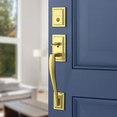 a blue door with a gold handle in front of a white couch and coffee table