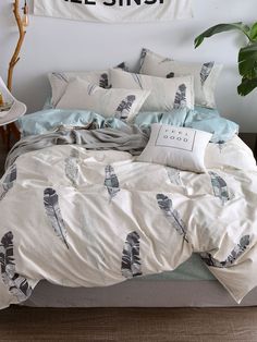 a bed with blue and white comforters in a bedroom next to a wall hanging