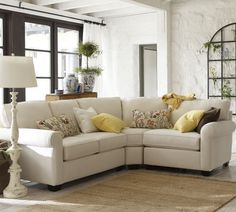 a living room filled with furniture and lots of pillows on top of the couches