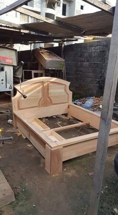 a wooden bed frame sitting in the middle of a yard