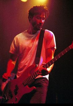 a man playing a bass guitar on stage