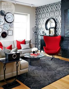 a living room filled with furniture and clocks on the wall