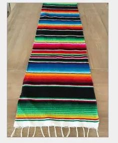 a multicolored striped rug with tassels