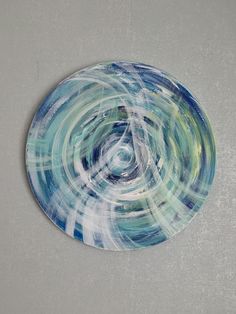 a blue and white plate with swirls on it sitting on a gray table top