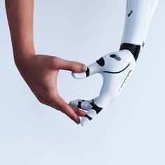 a hand holding a robot that looks like it has eyes and hands on the arm