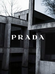 the words prada are displayed in front of an image of a building made out of concrete