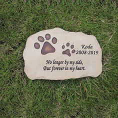 a memorial stone with a dog's paw prints on it