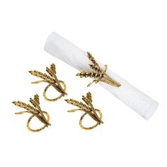 three napkin rings with gold leaves on them