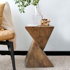 a vase with a plant in it sitting on a table next to a leather chair