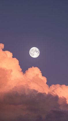 the full moon is seen through some clouds