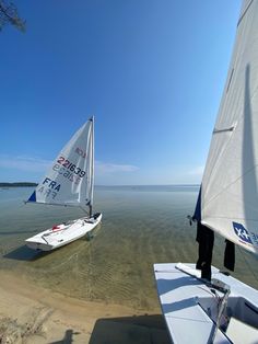 two small sailboats on the water near each other