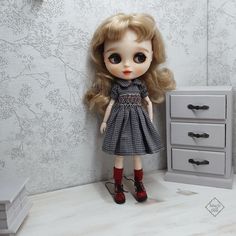 a doll is standing next to a dresser