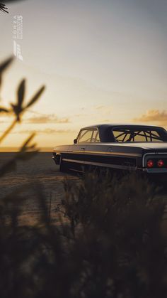 an old car is parked on the side of the road near some grass and bushes