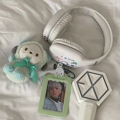 headphones, an mp3 player and a stuffed animal on a bed