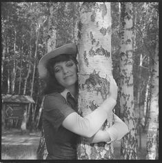 black and white photograph of a woman hugging a tree