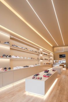 the inside of a shoe store with lots of shoes on shelves and wooden flooring