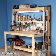 a workbench with lots of tools on it in a blue walled room next to two stools