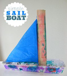 a blue sailboat sitting on top of a white table next to a wooden pole