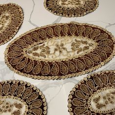 four brown and white placemats on a marble table