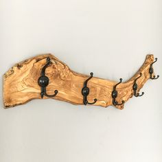 a piece of wood that has hooks on it and is attached to the wall with black iron brackets