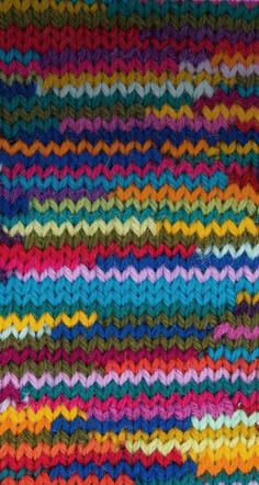 a multicolored knitted blanket with wavy lines