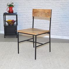 a wooden chair sitting in front of a painting on the wall next to a shelf