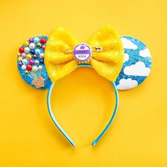 a yellow and blue mickey mouse ears with beaded decorations on it's ears