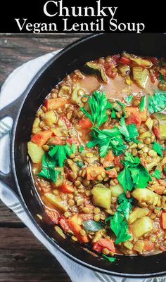 chunky vegan lentil soup in a skillet on top of a wooden table