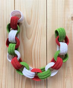 a crocheted christmas wreath hanging on a wooden fence with the words pattern written below it