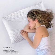 a woman laying on top of a pillow with her arms resting against the pillow cover