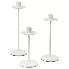 three white candlesticks are standing next to each other on the same stand as one candle