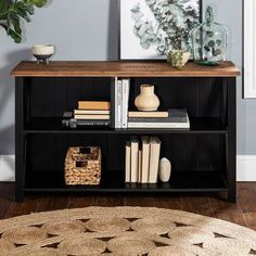 a book shelf with books and vases sitting on top of it next to a rug