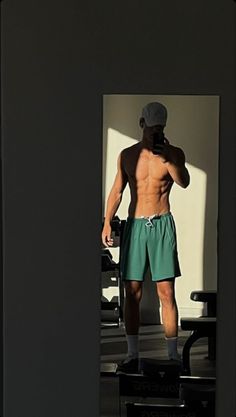 a shirtless man standing in front of a mirror