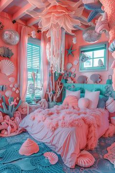 a bedroom decorated in pink and blue with lots of sea creatures hanging from the ceiling