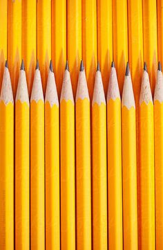 many yellow pencils lined up in a row