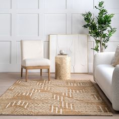 a living room with white furniture and a rug