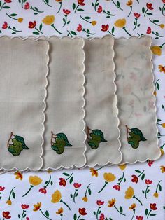 four pieces of cloth with flowers and leaves on them, one has a green frog