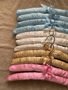 a pile of different colored pillows sitting on top of a floor next to each other