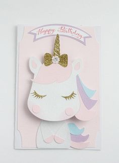 a pink card with a unicorn face and gold glitter on the top, says happy birthday