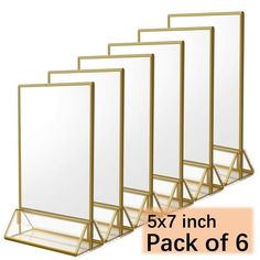 four mirrors are lined up in a row on a white background, one is gold and the other is clear